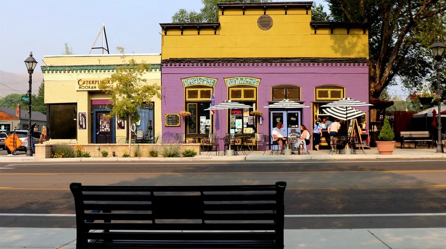 A bench across the street from an eatery and a hookah lounge in Carson City, Nevada.