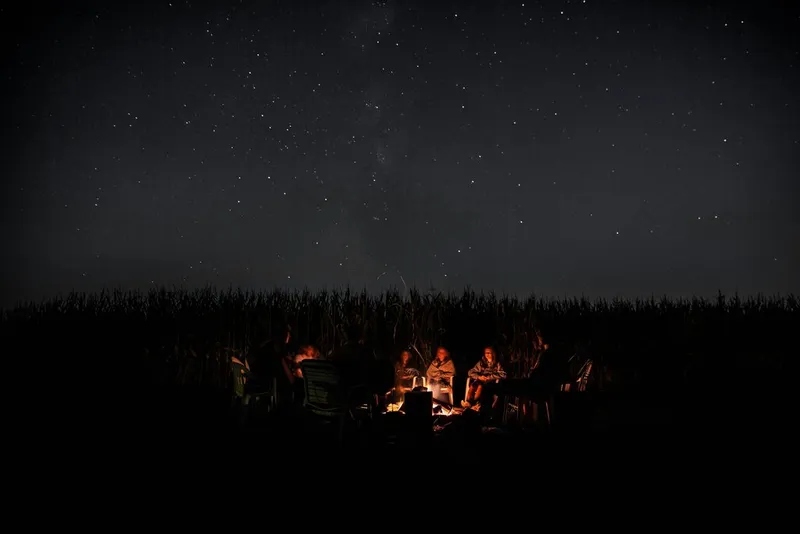 Group of people sitting around a campfire