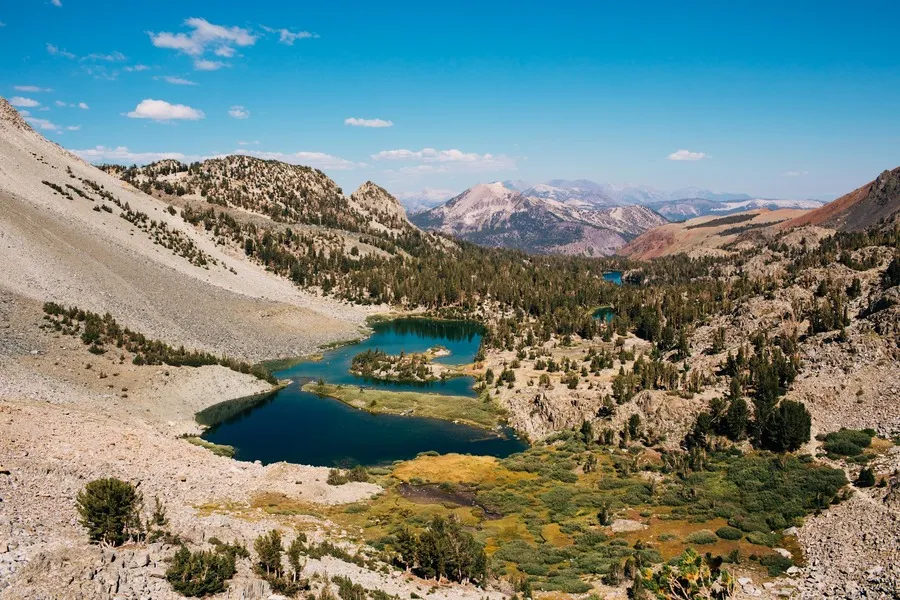 A picture of a mountain slope and lake with forestry near the town of Mammoth Lakes.