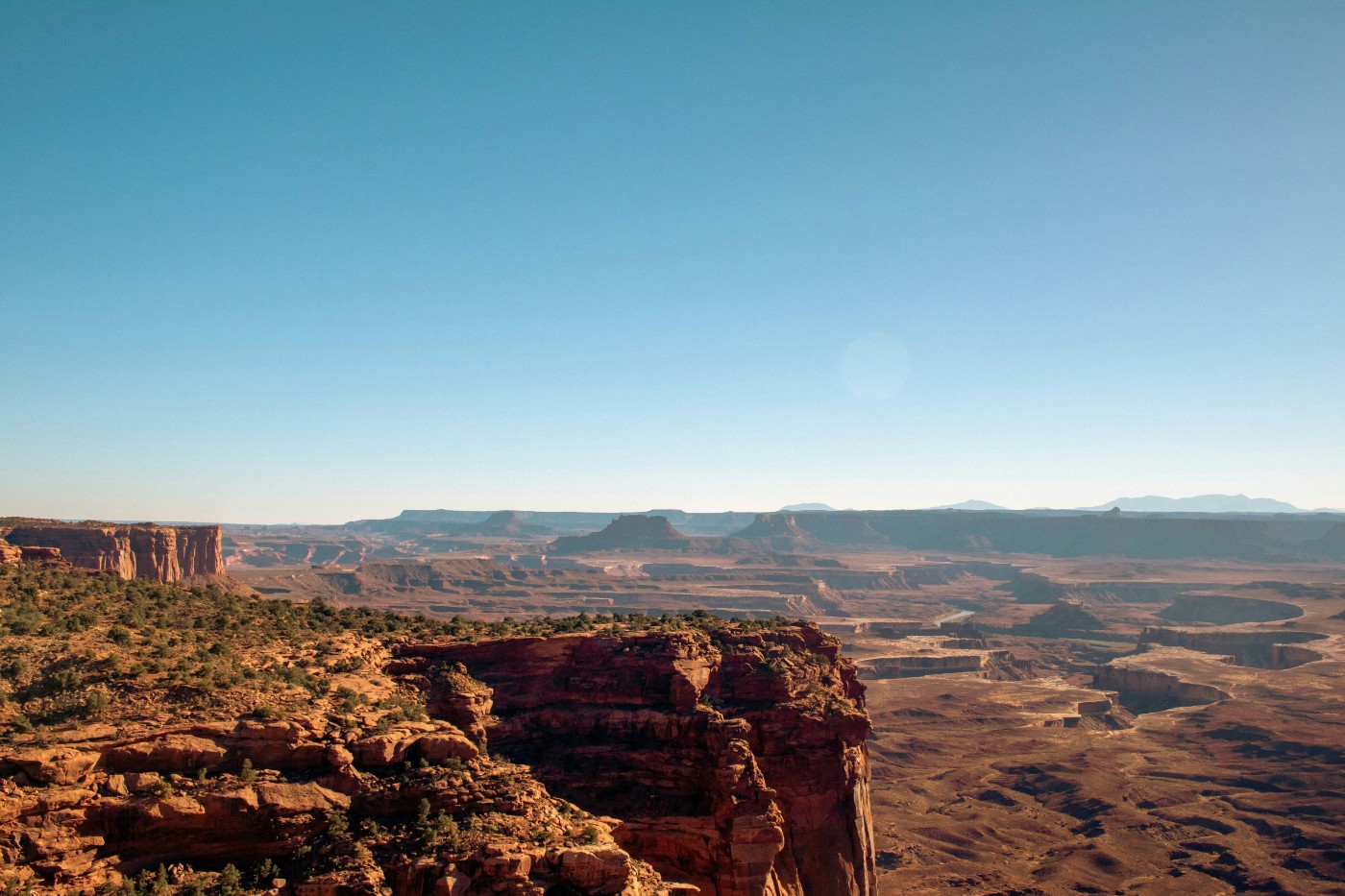 A majestic desert canyon with green bushes at Canyonlands National Park, Utah.