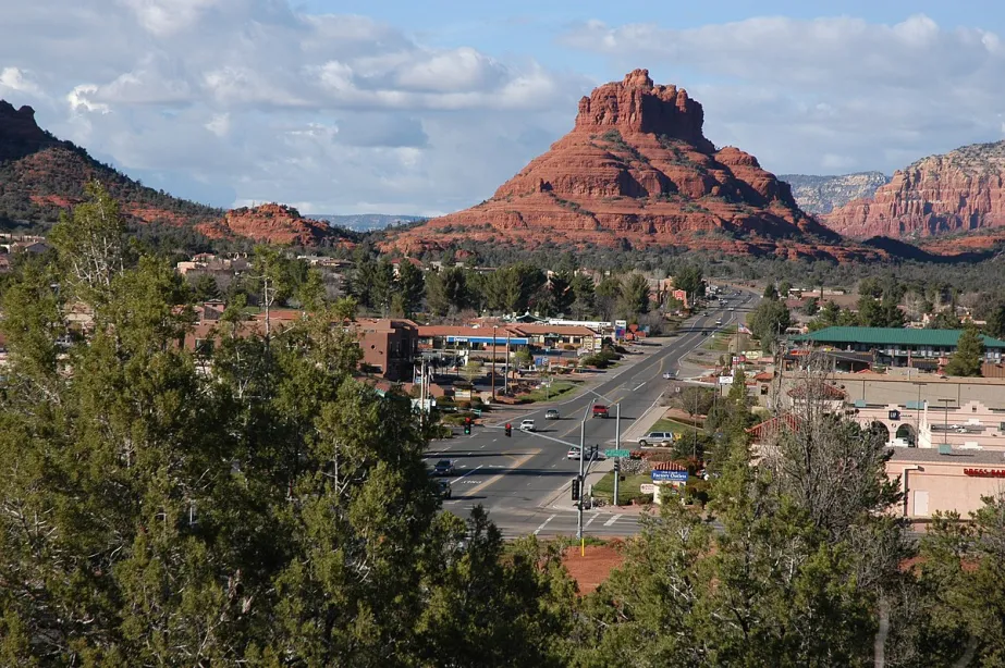 An aerial photo of The Village of Oak Creek near Sedona, featuring a main street and red rock formations in the background.